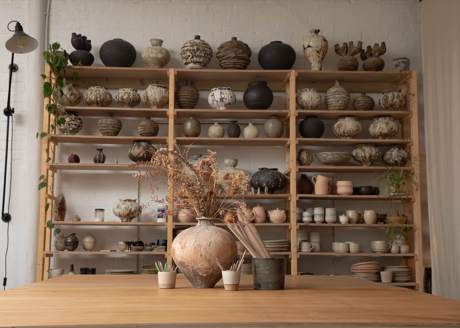 Shelves of finished work across the studio wall